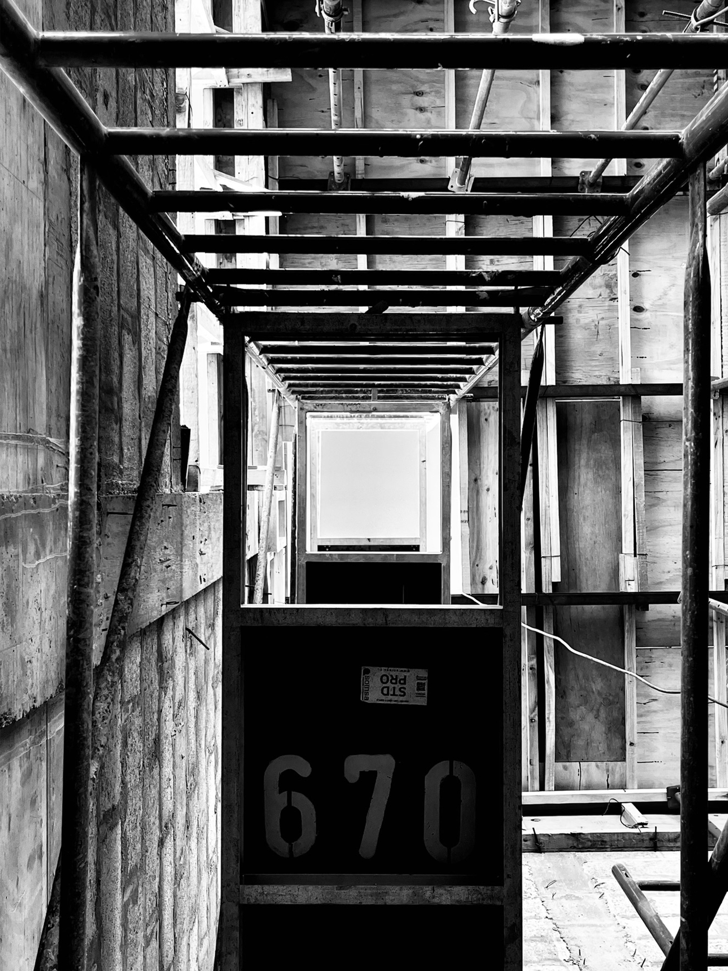 Vista en perspectiva de estructura de obra en construcción con andamios y numeración "670"
